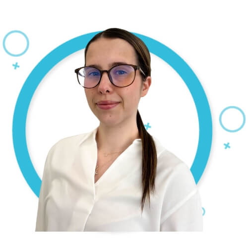 Nicole Bilder, Administrator at M Physio, wearing glasses and a white blouse, smiling slightly in front of a white background with blue graphic circles.
