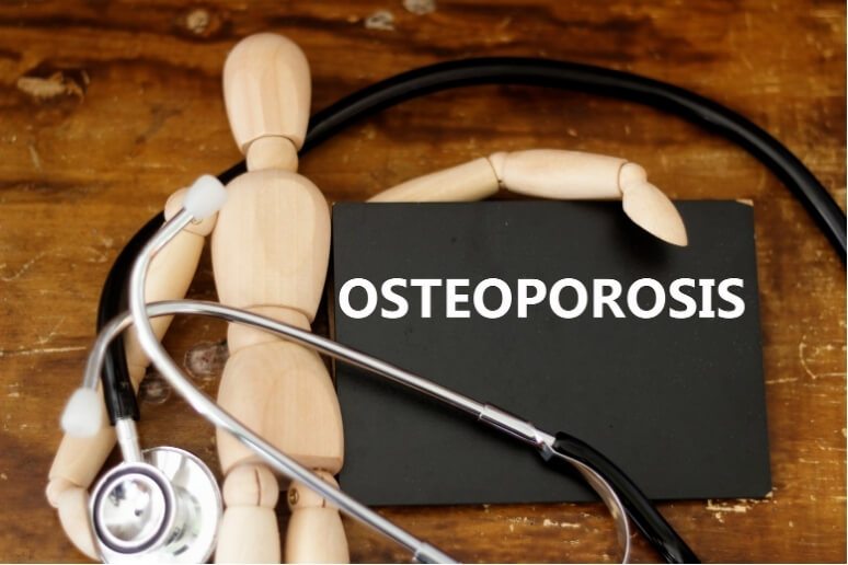 Wooden mannequin figure with a stethoscope and a blackboard labeled "OSTEOPOROSIS," symbolising bone health awareness and medical care.