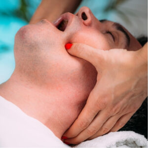 Physiotherapist applying intraoral manual therapy to treat jaw pain from Temporomandibular Disorder (TMD).