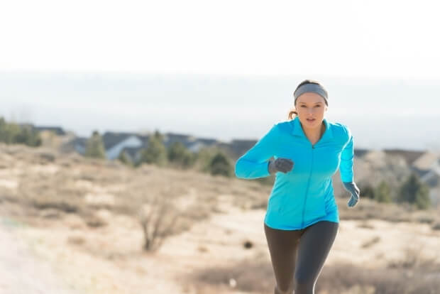 Female runner in winter gear exercising outside, illustrating cold weather injuries prevention