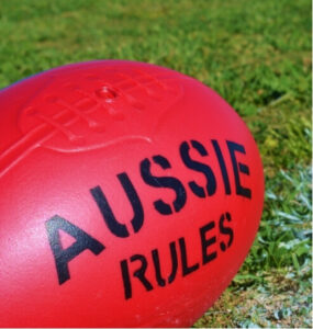 Red Aussie Rules football on field – ACL injuries in Australian sport