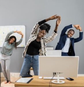 Employees stretching at their desks to reduce spinal pain from desk jobs.