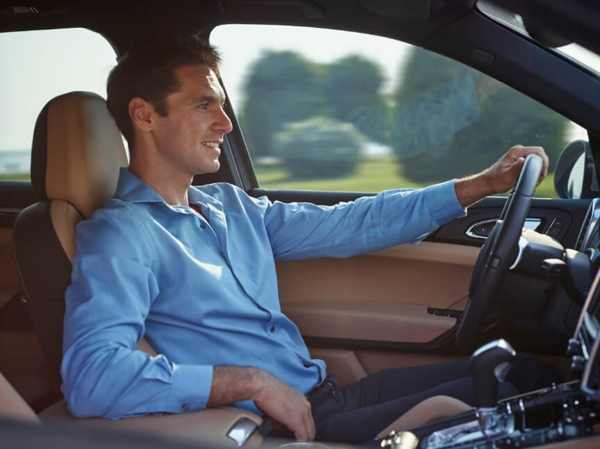 Man driving for work, a common cause of driving and low back pain.