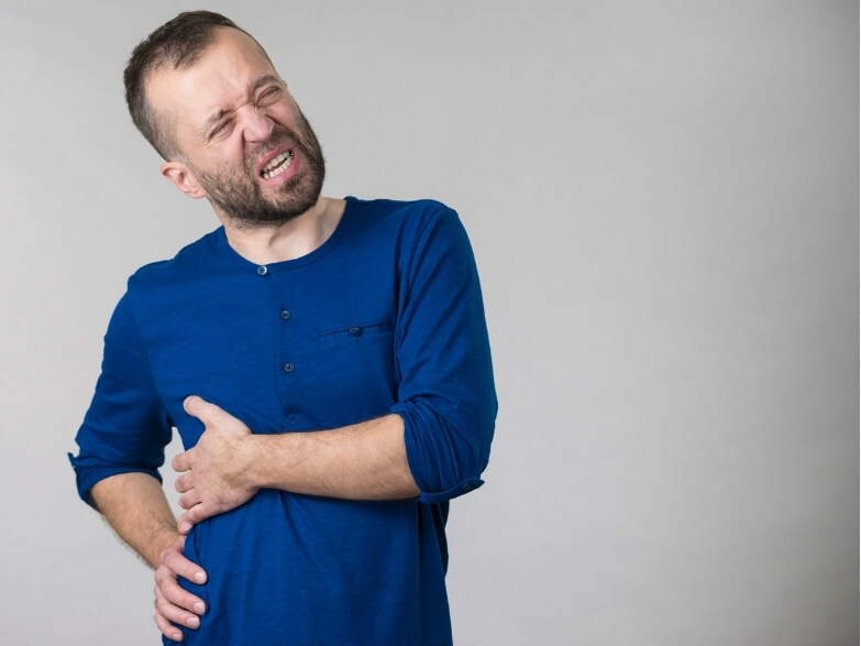 Man clutching ribs in pain – a common presentation requiring rib pain physiotherapy