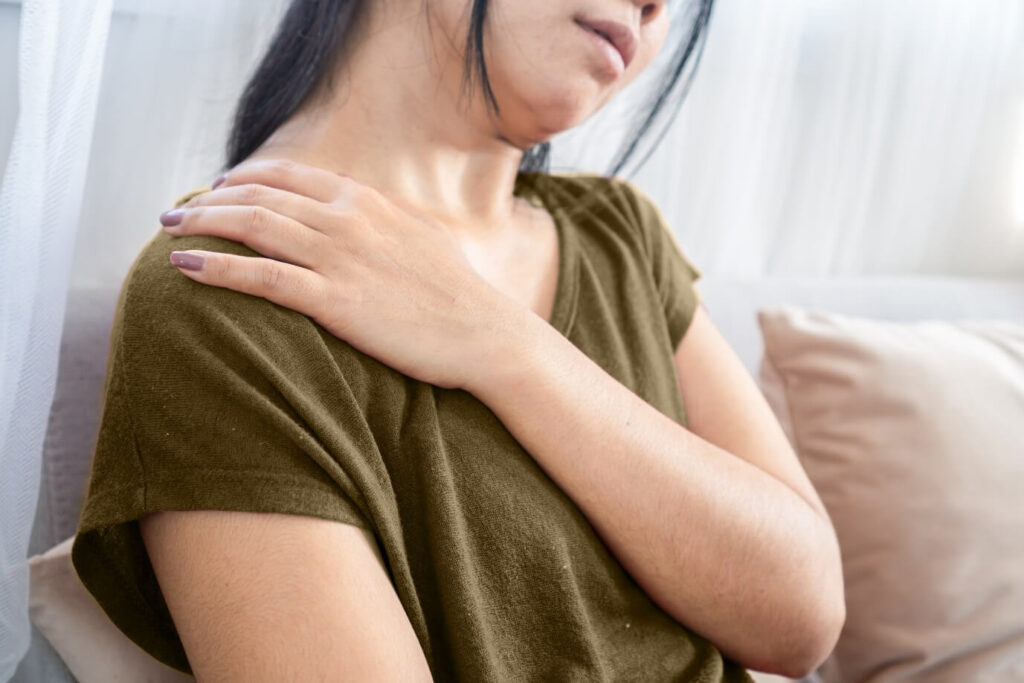 Woman experiencing shoulder pain during frozen shoulder treatment recovery