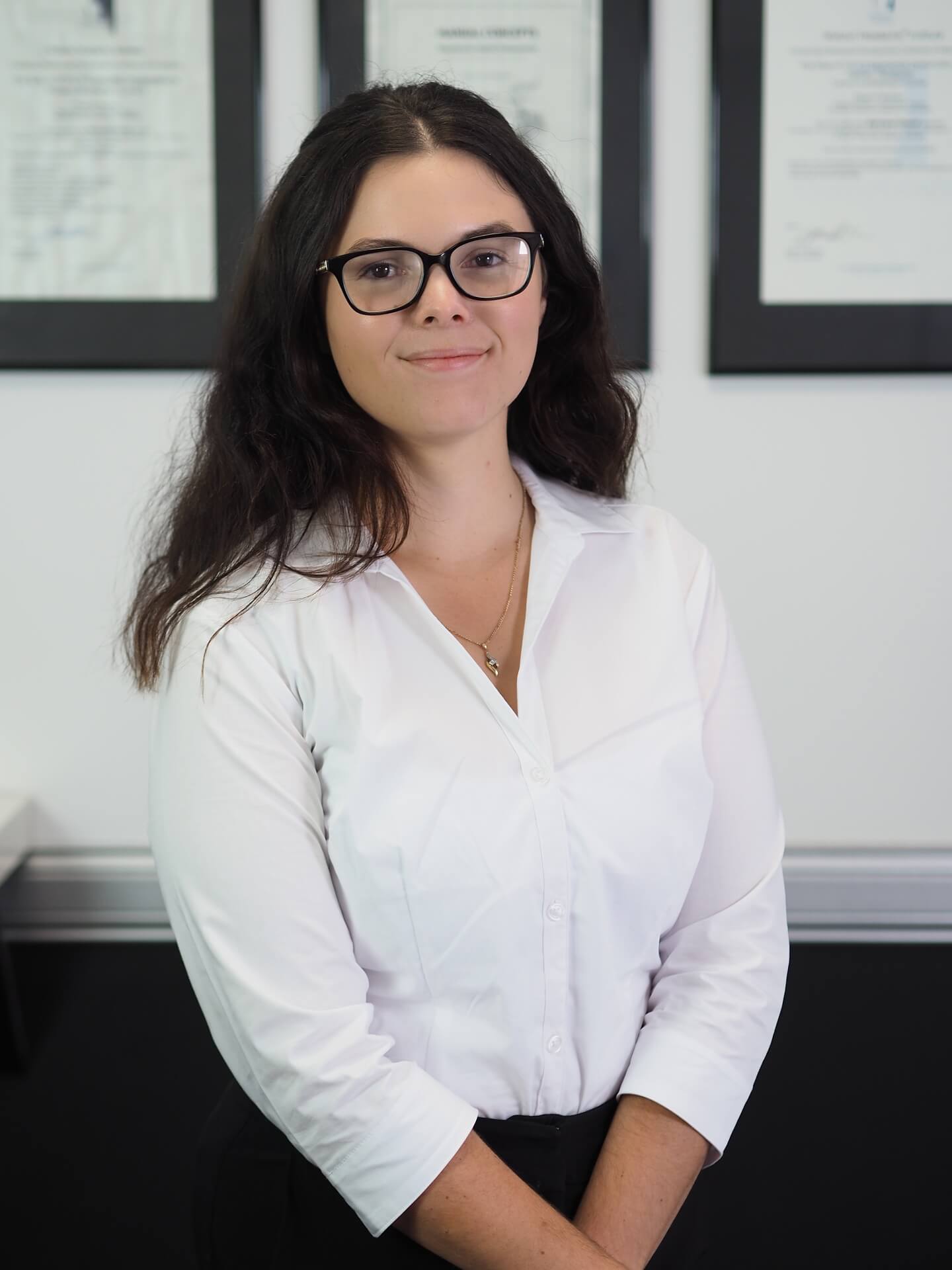 Rebecca Lay standing in front of certificates as a portrait
