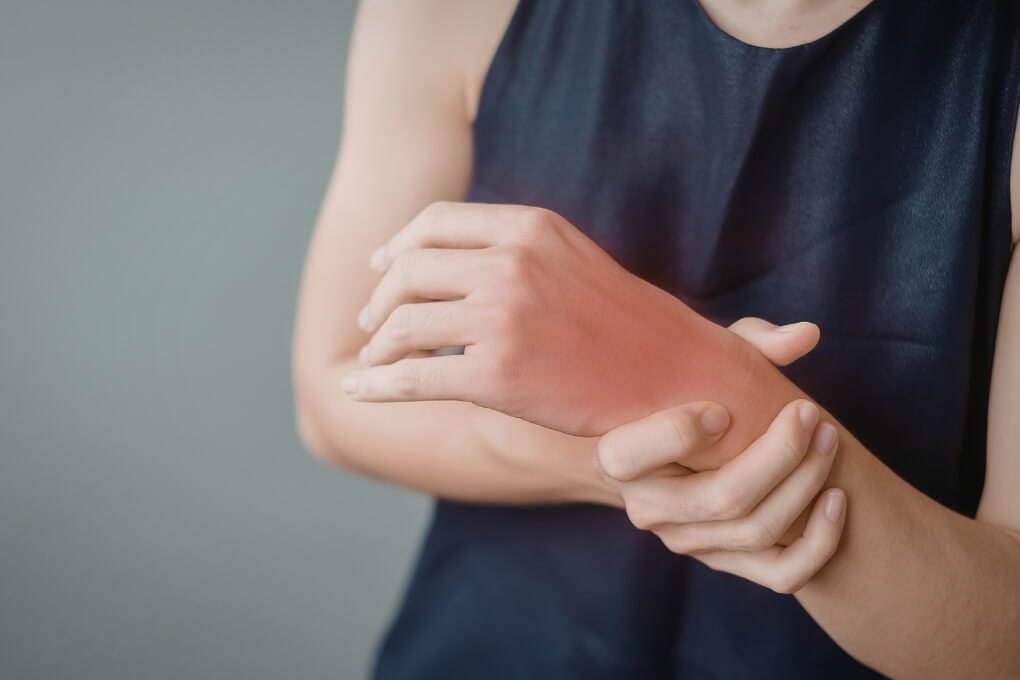 Person experiencing wrist pain after a fall during physiotherapy assessment