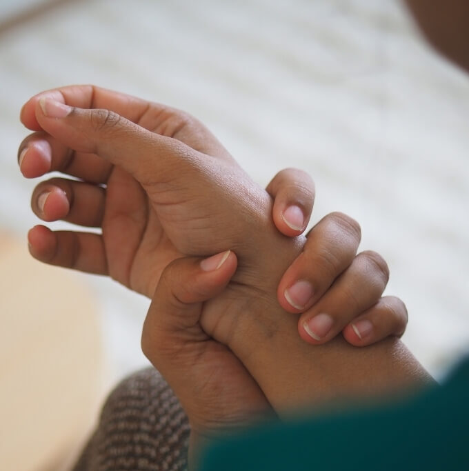 Person experiencing thumb side wrist pain associated with De Quervain’s Syndrome